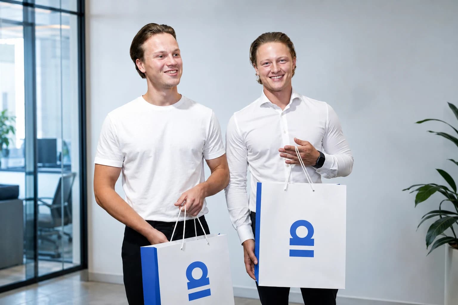 Pim Smit and Bink Sanders carrying Ainomiq bags